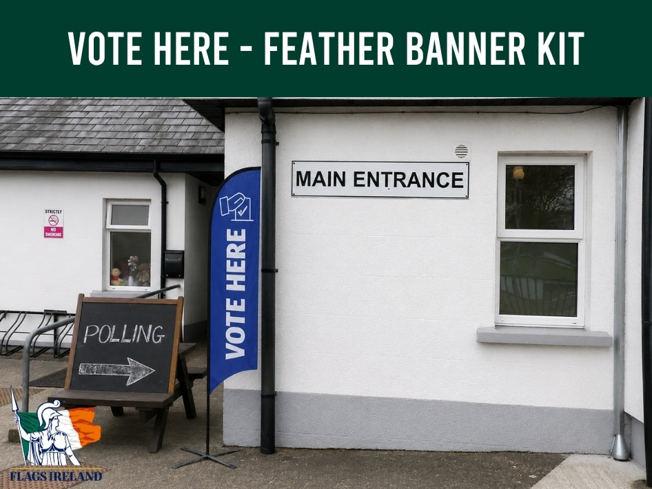 Voting station with 'Vote Here' feather banner and polling sign outside a building.