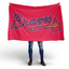 Person holding a red Atlanta Braves flag on a white background