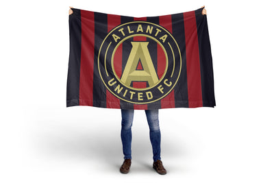 Person holding a Atlanta United FC flag on a white background