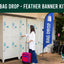 Person with a pink suitcase standing next to lockers with a 'Bag Drop' feather banner in the background.