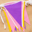 Purple, Golden Yellow and Pink triangle polyester bunting on a wooden surface