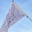 A light lavender flag with dark blue text reading 'CANDEN' and a geometric logo, attached to a silver flagpole against a bright blue sky with light clouds.