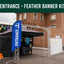 Entrance feather banner kit with blue banner and metal stand in front of a brick building.
