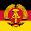 East Germany GDR Flag. The flag of the German Democratic Republic (GDR) is shown, featuring horizontal stripes of black, red, and yellow, with a central emblem of a golden hammer and sickle enclosed in a wreath of wheat.
