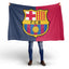 Person holding a Barcelona flag with the club's logo on a white background