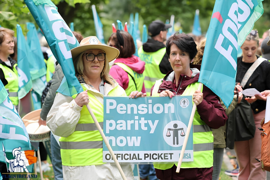 A group of people at an outdoor protest wearing high-visibility yellow vests and holding blue flags and signs, including one that reads 'Pension parity now' and 'Official Picket'.