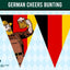 A triangular pennant banner design featuring the German flag colors with a cartoon beer-bowling figure on a light blue harlequin patterned background. A dark green banner at the top reads 'GERMAN CHEERS BUNTING' and a small 'Flags Ireland' logo appears in the lower left.