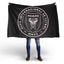 Person holding a black Inter Miami flag with Club Internacional de Fõtbol Miami logo