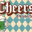 St Patrick's Day themed Oktoberfest graphic with the word 'Cheers' in a brown and white gothic font, 'Oktoberfest' below it, and a green beer mug with a shamrock on a beige and teal harlequin patterned background.