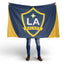 Person holding a LA Galaxy flag on a white background