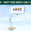 Table flag with 'LOVE' and 'Happy Pride Month' text, displayed with measurements against a blue sky background.