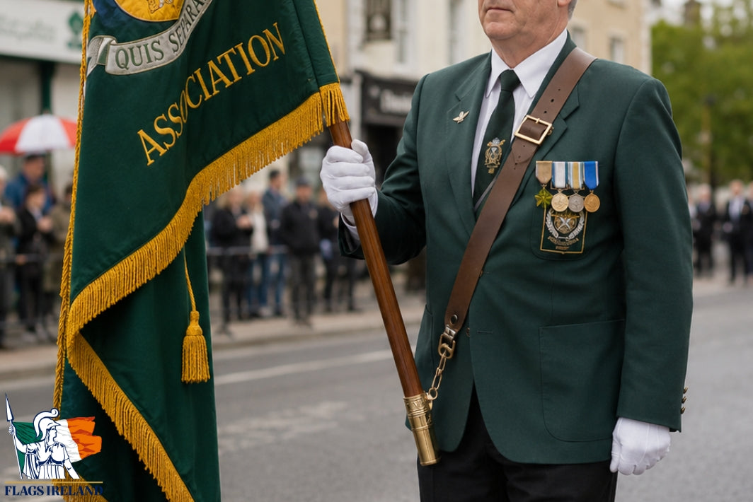 A man in a green military-style uniform holding a green flag with gold fringe and lettering stands on a street. The flag reads 'QUIS SEPARATUS ASSOCIATION.