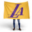 Person holding a yellow flag with a purple 'LA' logo on a white background. Los Angeles Lakers 