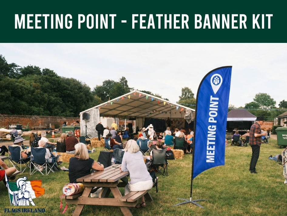 Outdoor event with people sitting at tables, a blue 'Meeting Point' banner, and Flags Ireland branding.