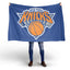Person holding a New York Knicks flag on a white background