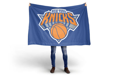 Person holding a New York Knicks flag on a white background