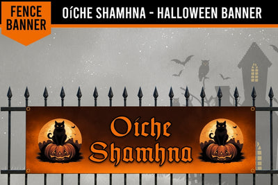 Halloween fence banner featuring the Irish Gaelic phrase 'Oíche Shamhna' in orange gothic lettering, flanked by black cat and jack-o'-lantern illustrations on an orange background, displayed on a black wrought-iron fence against a spooky gray background with silhouettes of a house, owl, and bats.