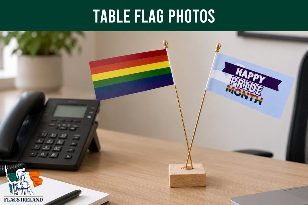 Two small flags on a desk with 'Happy Pride Month' message and 'Flags Ireland' branding.