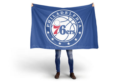 Person holding a Philadelphia 76ers flag on a white background