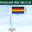 Philadelphia Pride flag on a wooden stand against a pastel striped background