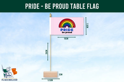 Pride-themed table flag with rainbow design and text 'PRIDE be proud' on a blue background.