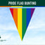 Pride flag bunting vertical stripes against a blue sky