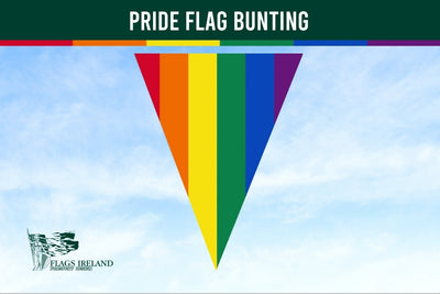 Pride flag bunting vertical stripes against a blue sky