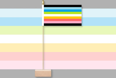 Colorful striped flag on a stand against a multicolored background. Queer Pride Table Flag.