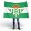 Person holding a green and white flag with a Real Betis crest on a white background