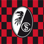 SC Freiburg Chequered Flag club crest centered on a red and black checkered background.
