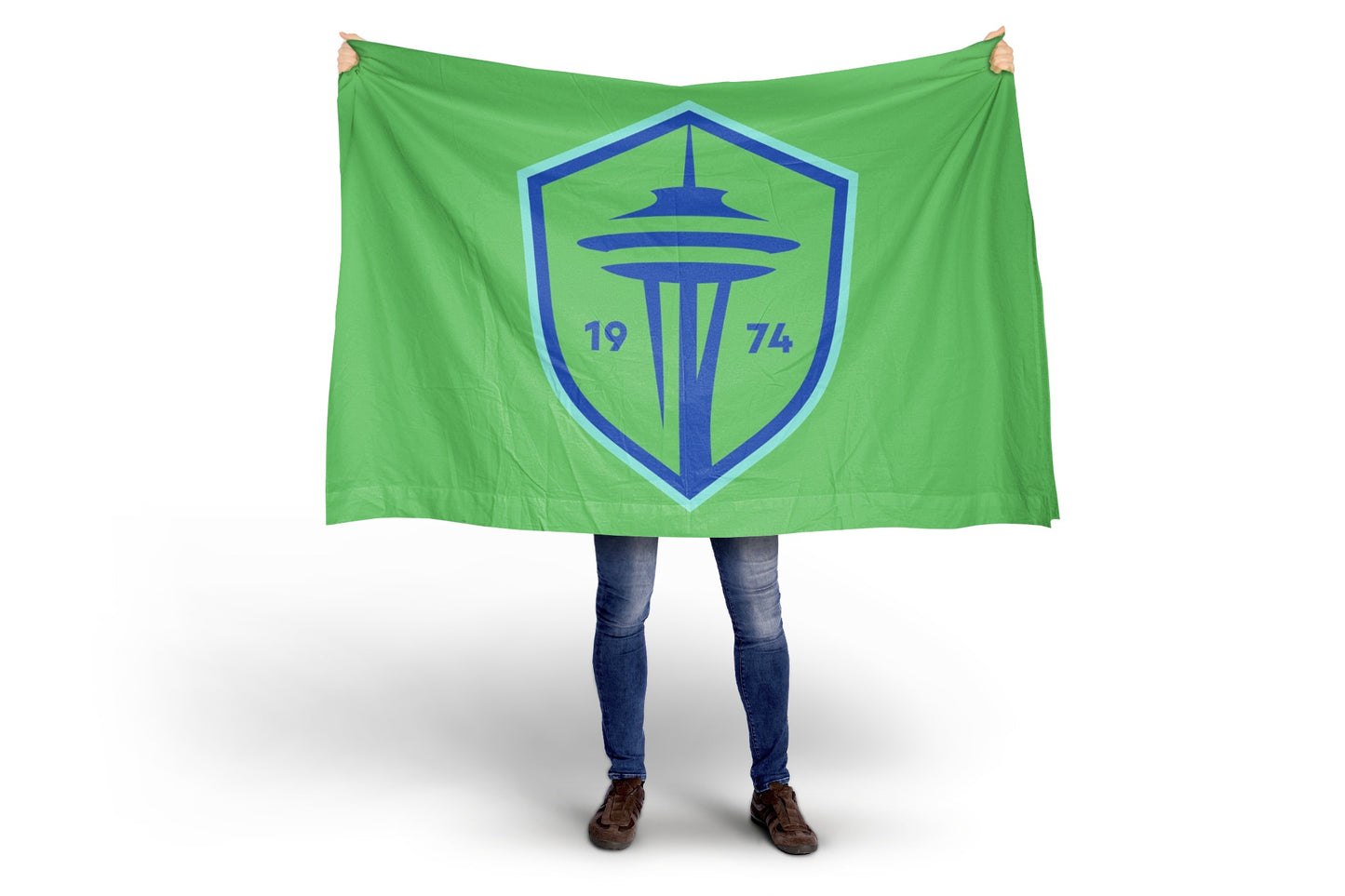Person holding a green flag with a blue logo featuring the Space Needle and the year 1974 on a white .background. Seattle Sounders FC Flag- New 2024 Crest