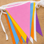 Colorful polyester bunting flags on a wooden surface