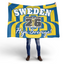 Person holding a large Sweden World Cup 2026 flag with blue and yellow stripes.