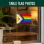 Rainbow Intersex Inclusive table flag on a wooden stand with a plant and blurred indoor background