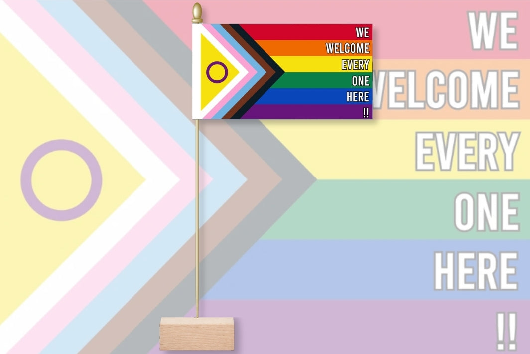 Flag with rainbow design and text 'We welcome everyone here' on a colorful geometric background. We Welcome Every One Here - Intersex Inclusive Pride 