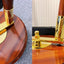 Close-up of a polished wooden flagpole base with a shiny gold metal flag mount and a dark reddish-brown wooden pole, shown in a split view with a small 'Flags Ireland' logo in the corner.