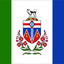 Flag with a coat of arms and floral elements on a green, white, and blue background. Yukon Flag.