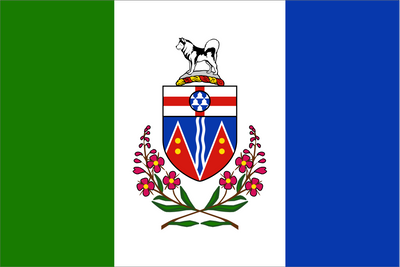 Flag with a coat of arms and floral elements on a green, white, and blue background. Yukon Flag.