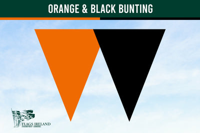 A graphic showing two large inverted triangles side by side in orange and black on a pale blue sky background, with a dark green banner at the top reading 'ORANGE & BLACK BUNTING' and a small 'Flags Ireland' logo in the lower left.