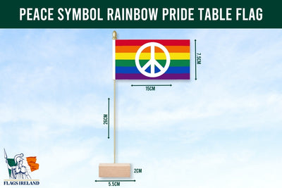 Rainbow pride table flag with peace symbol against a clear blue sky