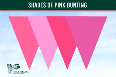 A graphic showing four overlapping pink triangular bunting flags in different shades of pink against a light blue sky background, with a dark green banner at the top reading 'SHADES OF PINK BUNTING' and a small 'Flags Ireland' logo at bottom left.
