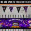 Halloween banner set displayed on a black metal fence against a gray background. The set includes a large rectangular banner reading 'WE ARE OPEN TO TRICK OR TREAT PACK' with a purple spooky scene, and triangular pennant banners hanging above.